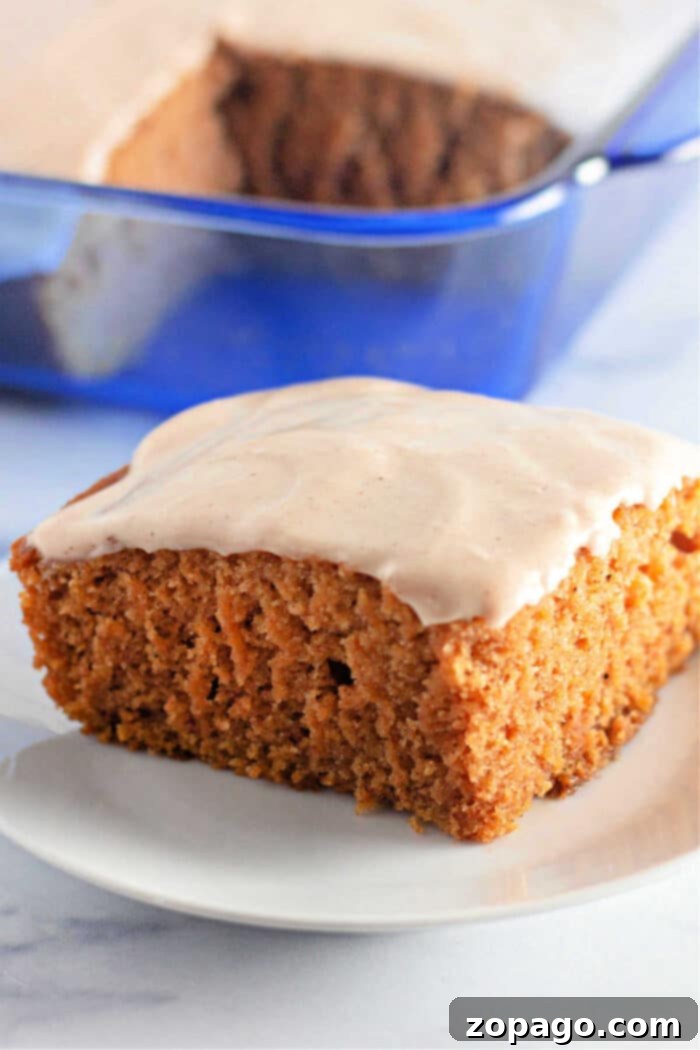Autumn Spice Pumpkin Delight 2 A beautifully frosted slice of dairy-free pumpkin crazy cake, resembling a classic crazy cake, served on a white plate with a vibrant blue dish in the background.