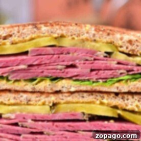 Close-up of a delectable corned beef sandwich recipe, featuring tender slices, crisp pickles, and fresh lettuce nestled between hearty whole grain bread.