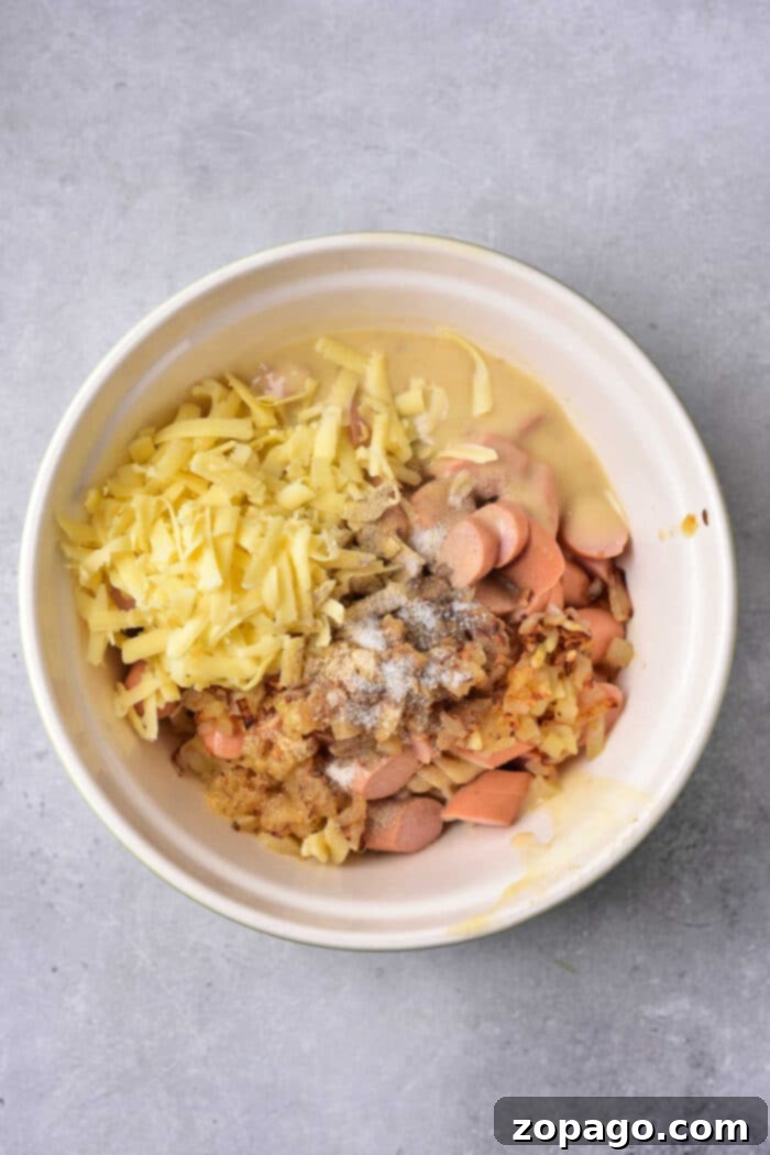 Cheesy Hot Dog Casserole Bake 4 Close-up of uncooked hot dog slices and al dente noodles, ready to be mixed into a casserole, highlighting the simplicity of preparation.