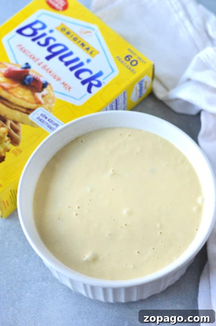 Easy Chicken Cobbler Bake with Bisquick 6 A bowl of bisquick batter sits invitingly next to a box of Bisquick pancake and baking mix on the countertop, perfectly ready to transform into the ultimate Chicken Cobbler Recipe delight.