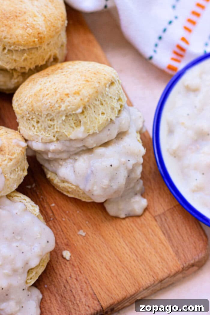 Pillowy Plant-Based Biscuits with Savory Gravy 6 A high-angle shot of a table laden with a warm breakfast spread, featuring a platter of fluffy vegan biscuits and a bowl of creamy vegan gravy ready to be served.