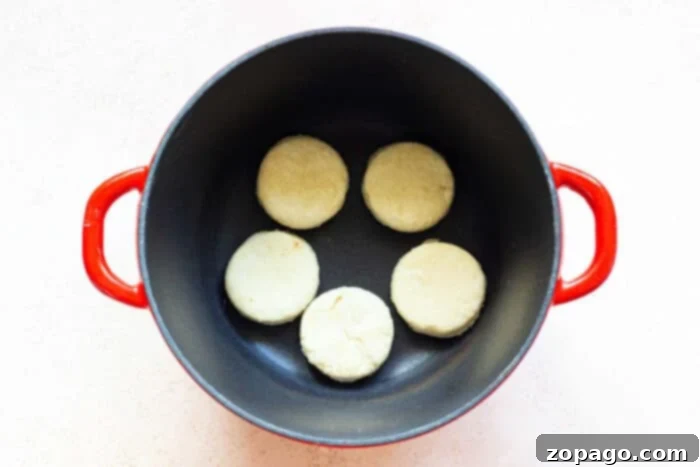 Homestyle Dutch Oven Biscuits 5 A Dutch oven baking biscuits over a campfire, showing the rustic cooking method.