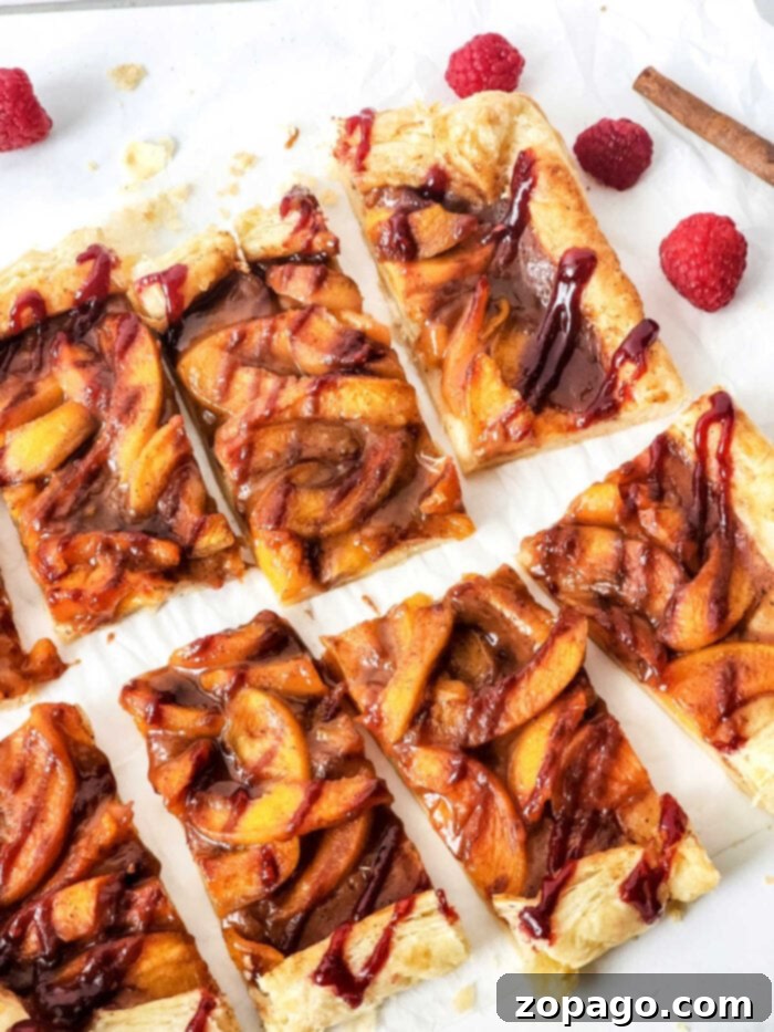 Golden Flaky Tart 2 Golden puff pastry fruit tart with peaches and a delicate drizzle, surrounded by fresh berries.