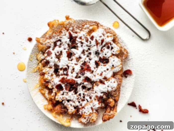 Funnel Cake without Eggs: Another view of the golden funnel cake, highlighting its intricate texture and inviting appearance.