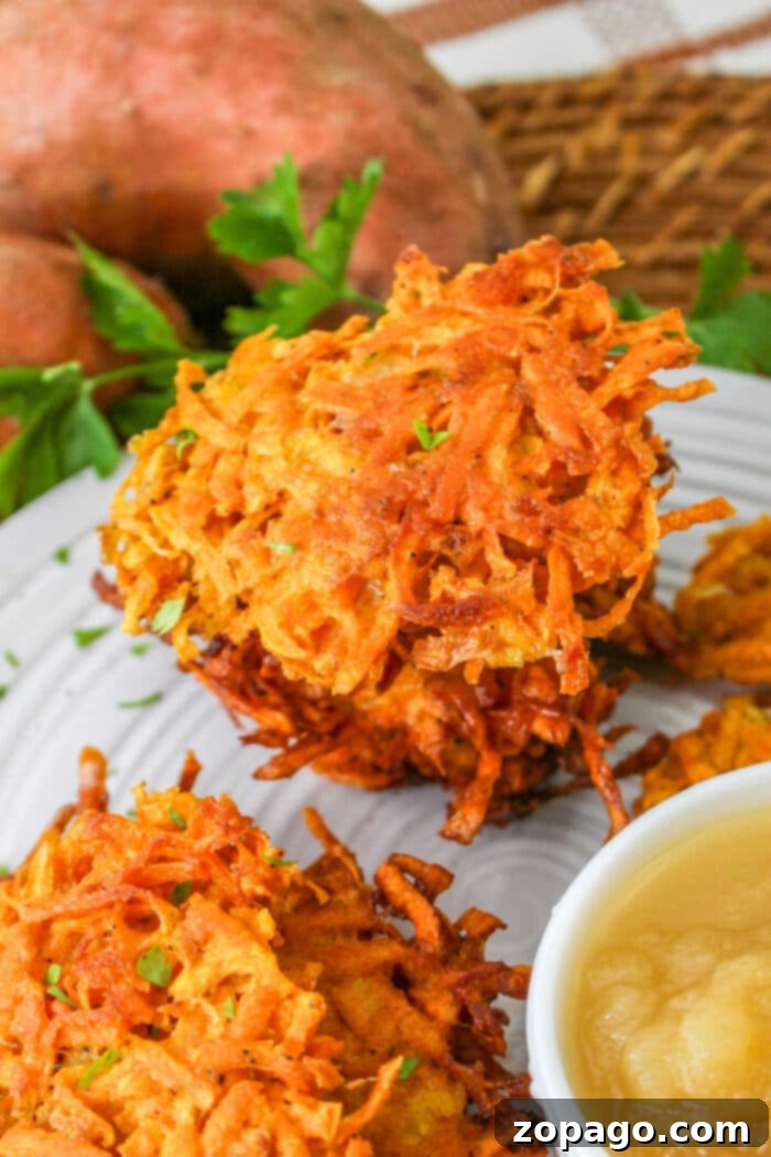 Golden Sweet Potato Latkes 2 Golden brown sweet potato latkes stacked on a plate