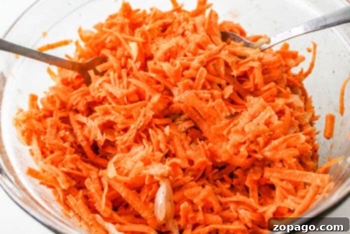 Golden Sweet Potato Latkes 4 A bowl of shredded sweet potato latkes batter, ready for sharing. Two forks invite you to dive into this delightful spread.