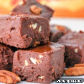 Close-up of chocolate fudge with Velveeta and pecan pieces stacked on a plate.