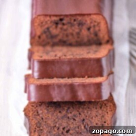 Molten Chocolate Brownie Loaf 7 Sliced brownie loaf cake, reminiscent of a rich brownie bread, rests on a wooden surface.