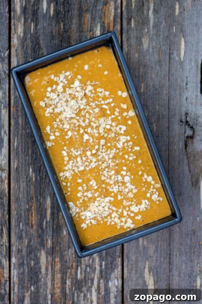 Golden Maple Pumpkin Loaf 5 Rustic maple pumpkin bread with a generous sprinkling of oats, expertly sliced and ready to serve.