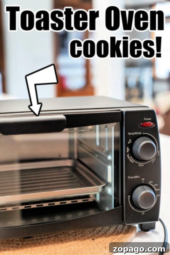 Toaster Oven Cookie Perfection 4 Toaster Oven Cookies - A close-up of a baking sheet filled with freshly baked chocolate chip cookies, indicating the perfect texture achieved in a toaster oven. Some cookies show melting chocolate chips.
