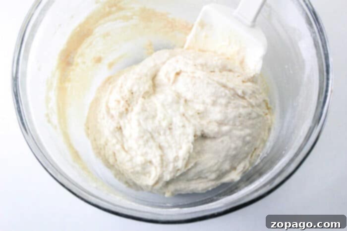 Creamy Mayo Buns 4 Two hands reaching for a plate of freshly baked mayo dinner rolls.