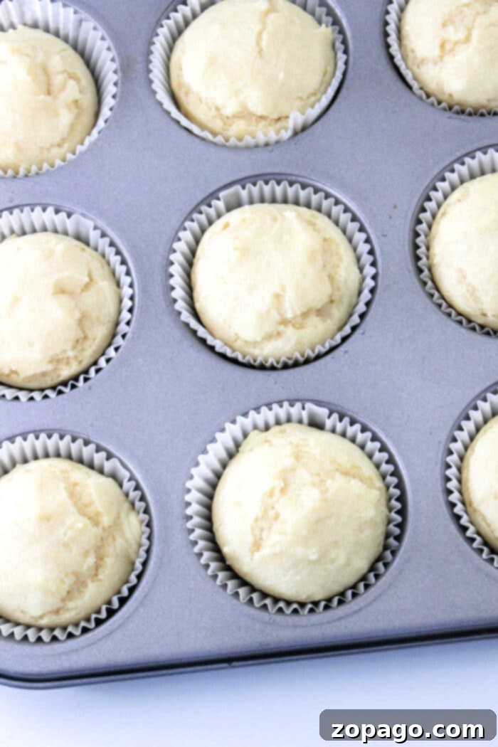 Creamy Mayo Buns 5 A hand gently tearing apart a warm mayonnaise roll, revealing its soft, fluffy interior.