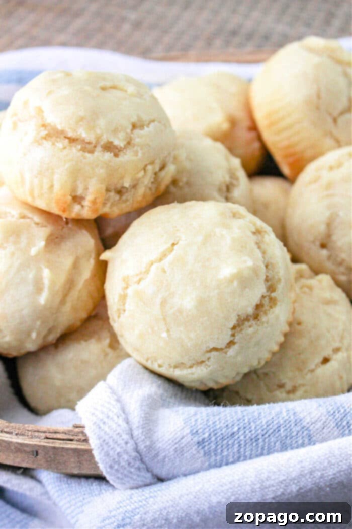 Creamy Mayo Buns 6 A large batch of mayonnaise rolls, glistening with melted butter, on a baking sheet.
