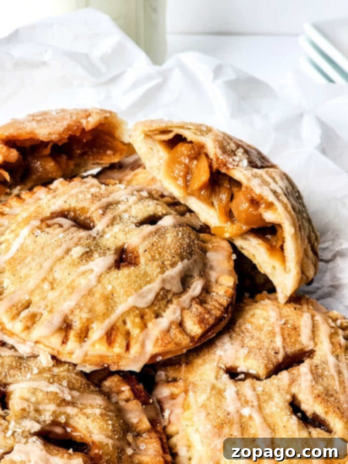 Golden-brown peach hand pies arranged on a cooling rack, fresh from the oven.