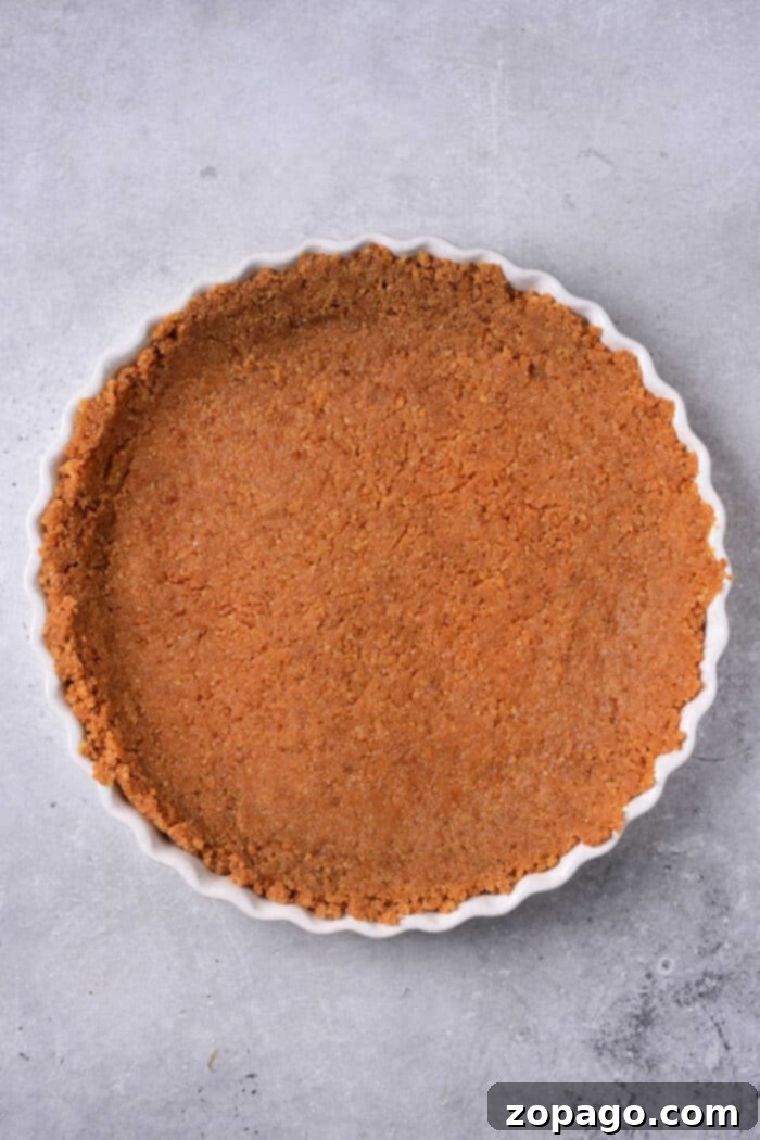 Creamy Pumpkin Custard Pie 4 Step-by-step image of preparing a graham cracker crumb crust for a pie.