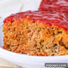Quick and Easy Stuffing Meatloaf 8 Close-up of a slice of Stove Top Stuffing Meatloaf topped with a tomato glaze on a white plate.