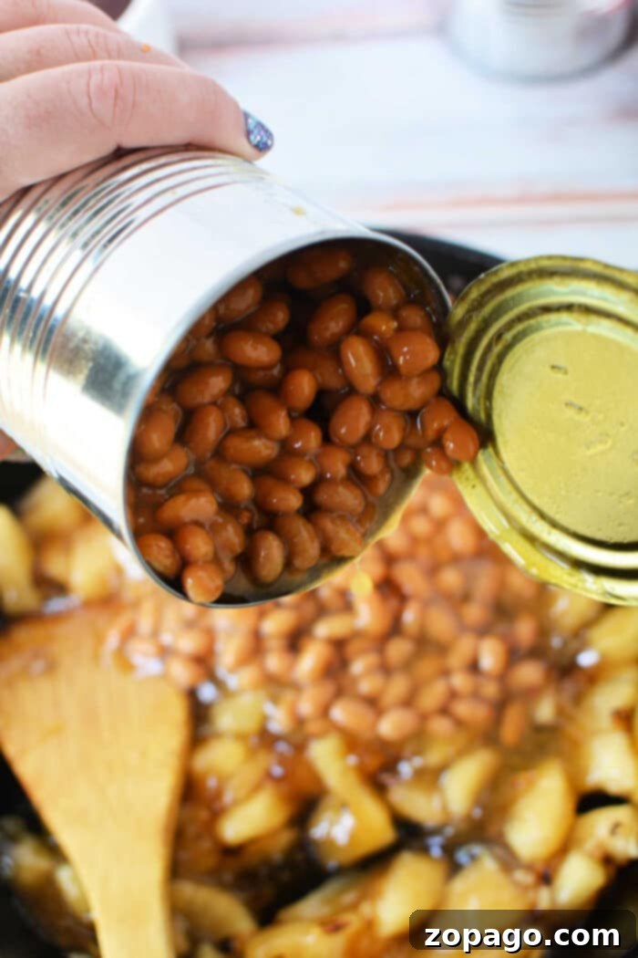 Sweet Apple Baked Beans Delight 6 Tips for Making Canned Baked Beans Better, served in a cast iron skillet.