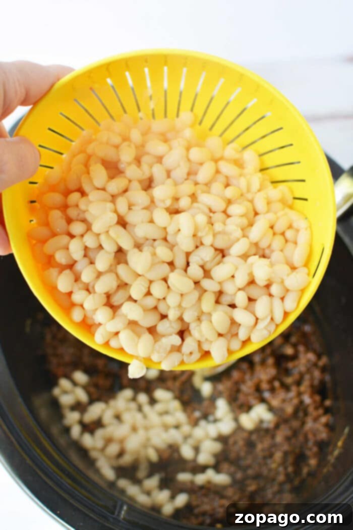 Cowboy Beef and Bean Casserole 5 Hearty baked beans with ground beef, rich with thick sauce, served in a bowl, made with dry beans, offering a rustic and deeply flavorful experience.