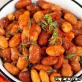 A bowl of seasoned roasted tepary beans garnished with fresh herbs.