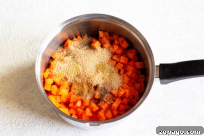 Pectin-Free Homemade Pumpkin Jam 4 Chopped pumpkin topped with brown sugar and cinnamon meld harmoniously in a saucepan, creating a delightful blend reminiscent of pumpkin jam.