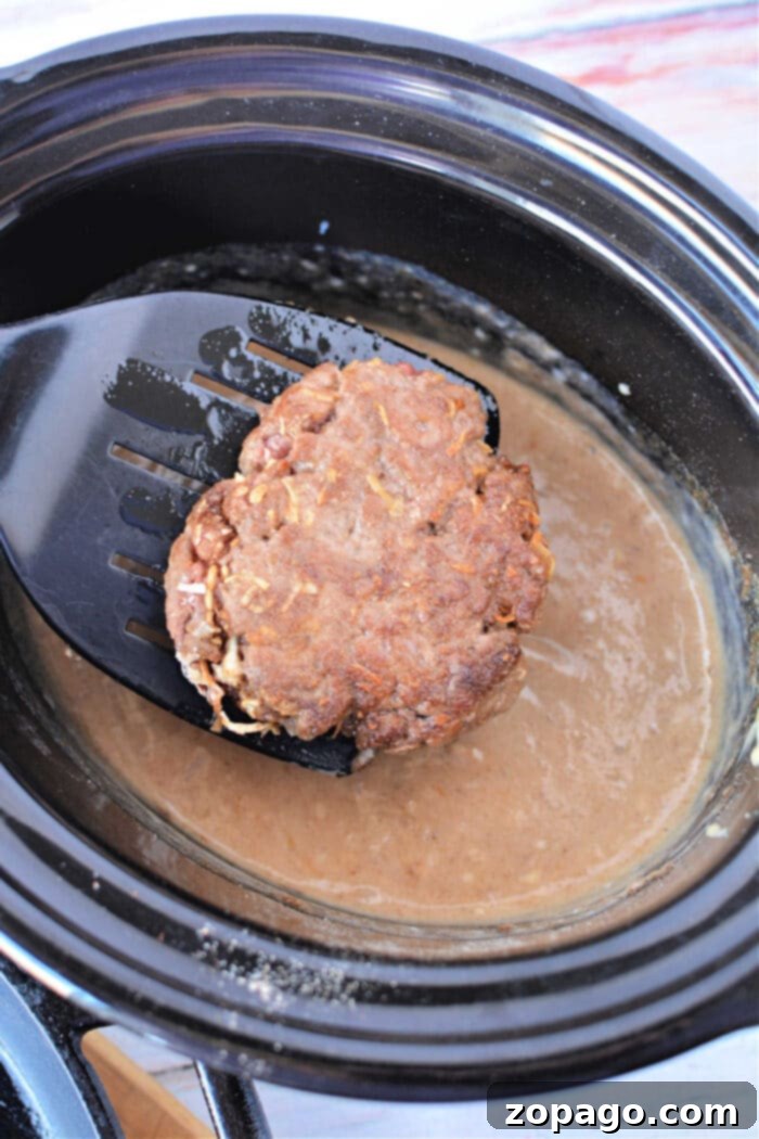 Ultimate Slow Cooker Salisbury Steak 5 Crockpot Salisbury Steak Recipe with Hamburger Patties served with mashed potatoes.