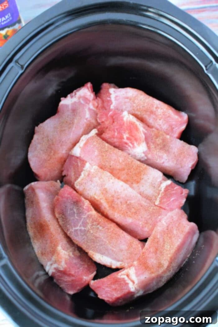 Fall Off The Bone Slow Cooker Country Ribs 5 Crockpot Country Style Ribs cooking in a slow cooker, covered in rich barbecue sauce.