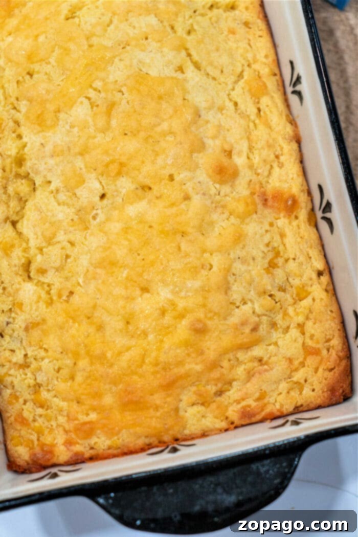 Effortless Cheesy Corn Bake 2 Golden cream cheese corn casserole in a black and white baking dish, perfect for holiday gatherings.