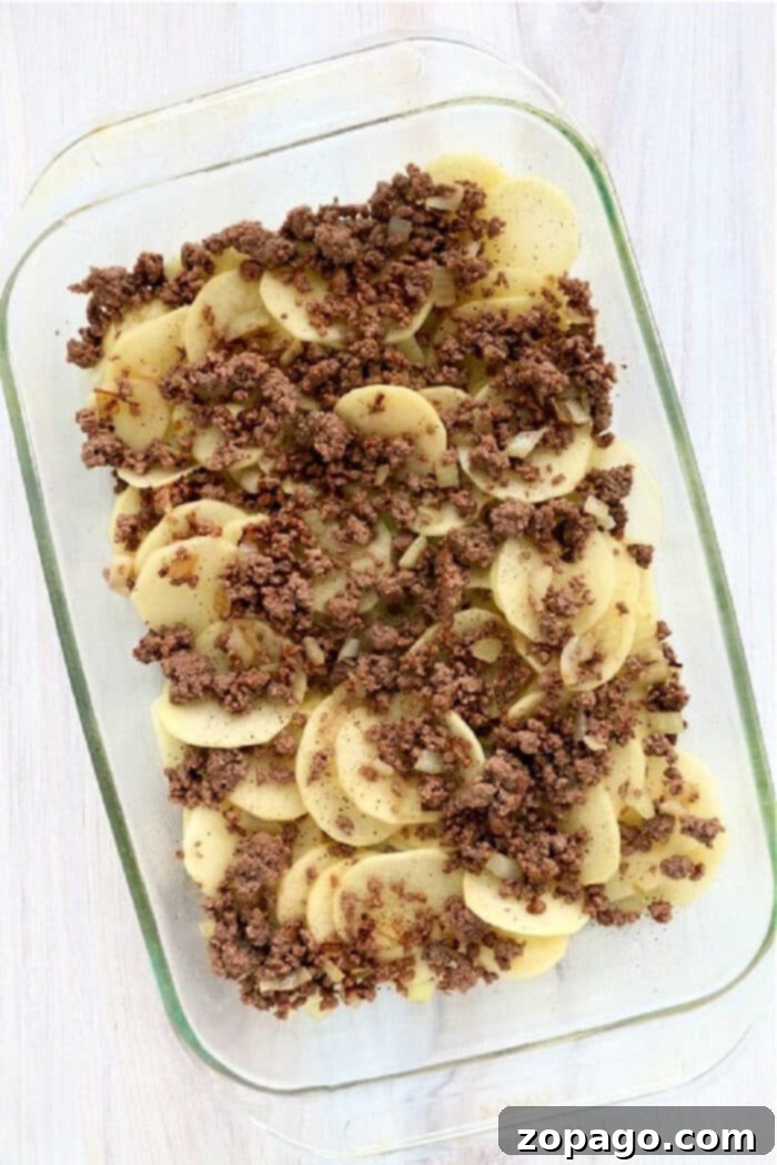 Hamburger Casserole 5 Ground Beef HotDish with melted cheese and fresh herbs, ready to serve.