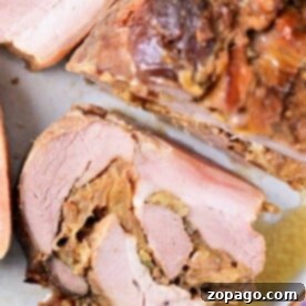 Savory Pork Pinwheels 5 Close-up of sliced pork roulade with a crispy outer layer on a plate.