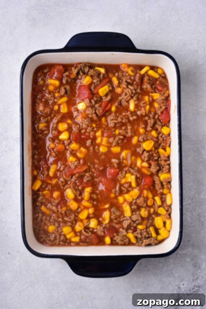 Zesty Mexican Cornbread Bake 3 Cornbread Mexican Casserole - A close-up of the delicious layers of a cheesy Mexican cornbread casserole.