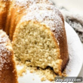 A sliced champagne bundt cake on a plate, elegantly dusted with powdered sugar.