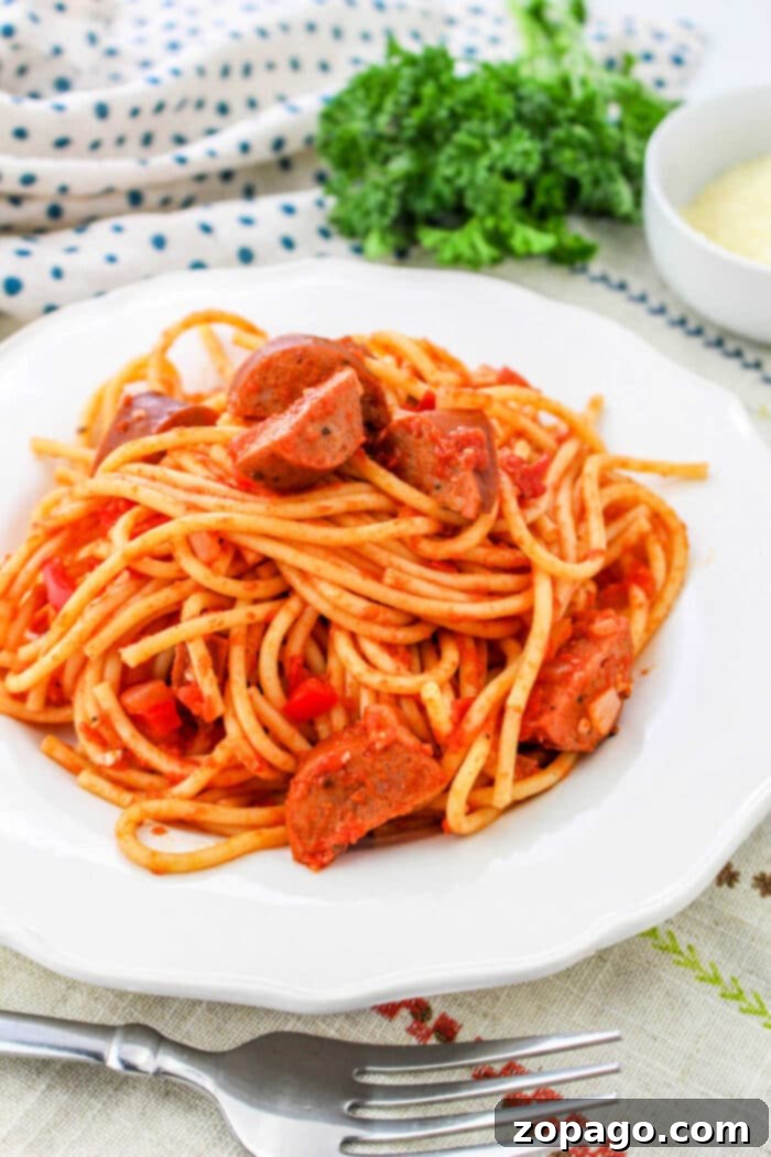 Hearty Sausage Spaghetti 8 Spicy Spaghetti, a close-up image capturing a fork twirling rich pasta, succulent sausage, and vibrant sauce, ready to be eaten.
