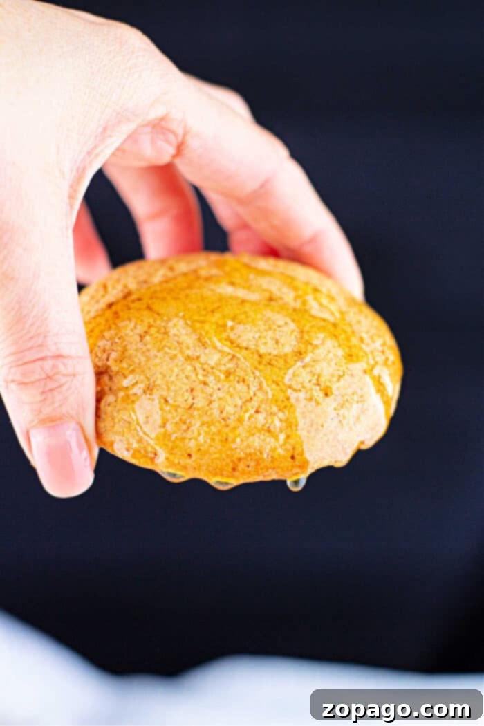 Golden Cornbread Cookies 2 Copycat Crumbl Cornbread Cookie, drizzled with honey, on a dark background.