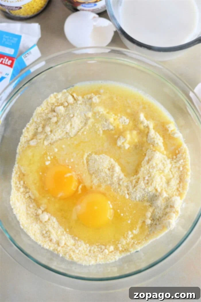 Creative Ways to Use Leftover Cornbread 3 On a kitchen counter, a bowl filled with cornbread mix, two eggs, and melted butter sits among baking ingredients. Get creative with leftover cornbread recipes by mixing these basics into delightful treats.