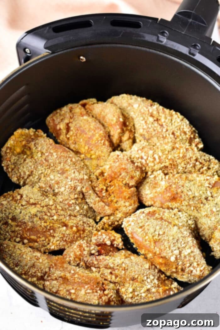 Creative Ways to Use Leftover Cornbread 4 Breaded chicken pieces in an air fryer basket, ready to be cooked to crispy perfection, make a delightful pairing with your favorite leftover cornbread recipes.