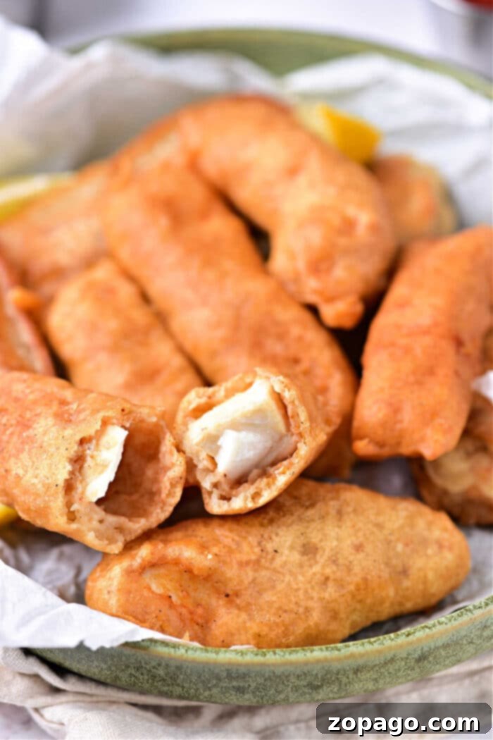 Two pieces of crispy beer battered halibut on a plate, ready to be enjoyed.