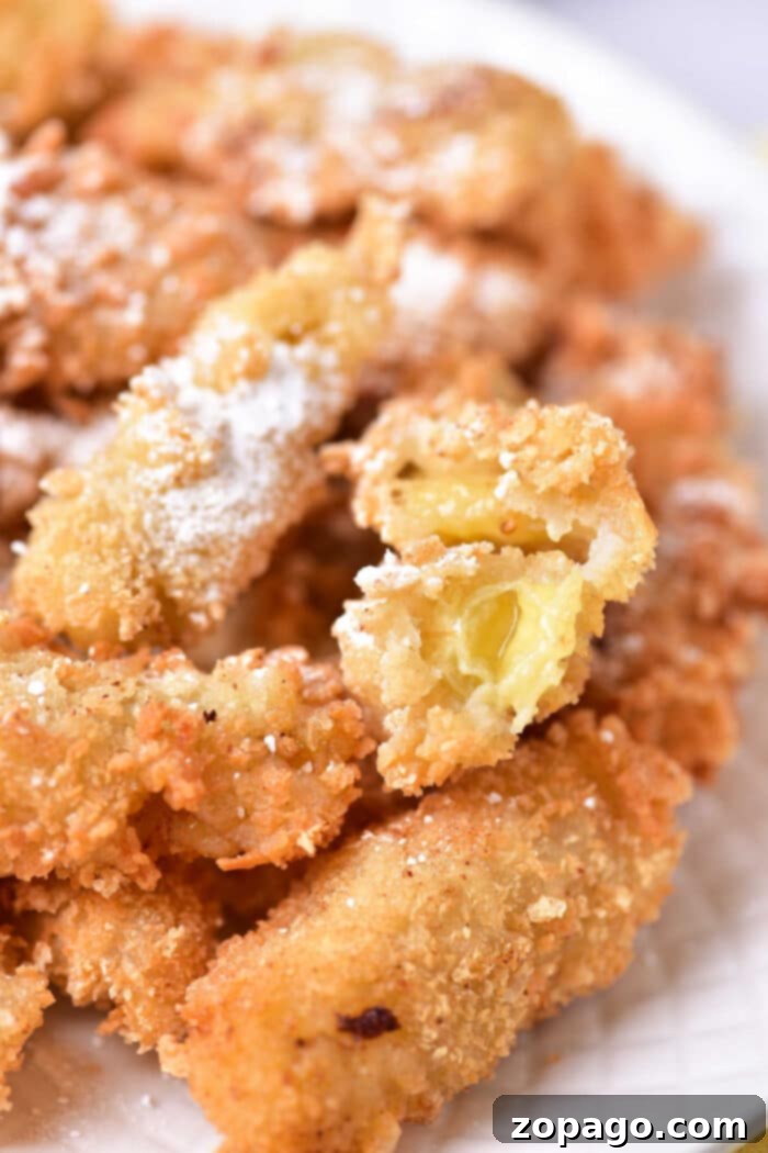 Crispy Banana Tempura Delight 6 Crispy fried bananas dusted with powdered sugar, served as a delectable dessert.