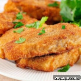 Close-up of crispy Fish Fry fillets, perfectly breaded and fried, garnished with fresh parsley on a pristine white plate.