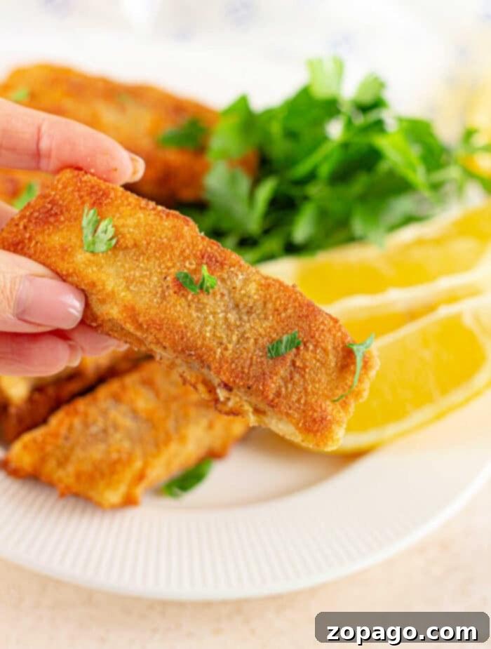 Crispy Fish Feast 8 A serving of crispy, golden fish fry fillets on a white plate