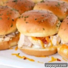 Savory Chicken Bacon Ranch Sliders 6 Close-up of Chicken Bacon Ranch Sliders showcasing juicy chicken, melted cheese, and crispy bacon on toasted buns topped with fresh herbs.