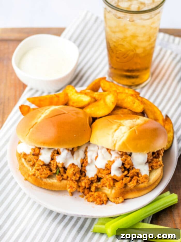 Hearty Chicken Sloppy Sandwiches 10 Close-up of a delightful Buffalo Chicken Sloppy Joe on a bun, showcasing the rich sauce and a sprinkle of fresh herbs.