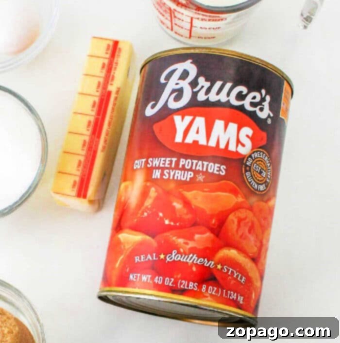Soulful Southern Sweet Potato Pie 3 A can of Bruce’s Yams, labeled "Cut Sweet Potatoes in Syrup" and "Real Southern Style," displayed alongside a stick of butter, a measuring cup, and other cooking ingredients. This setup is perfect for showcasing the ease of using canned yams for a sweet potato pie with sweetened condensed milk.