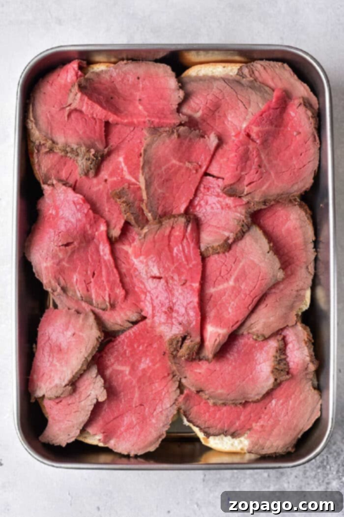 Delicious Ways to Use Leftover Tri Tip 5 Perfectly seared slices of rare tri-tip beef, arranged in a sleek metal tray, showcasing its readiness for various leftover recipes.