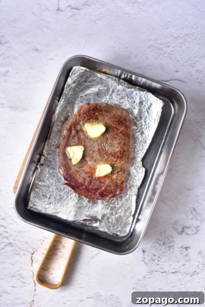 Perfectly baked steak resting on a cutting board, ready to be sliced, emphasizing the importance of reheating methods.