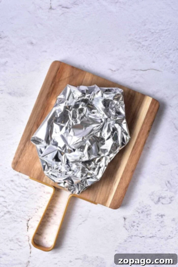 A perfectly cooked steak with a beautiful crust, resting on a wooden board, ready to be sliced for maximum juiciness.