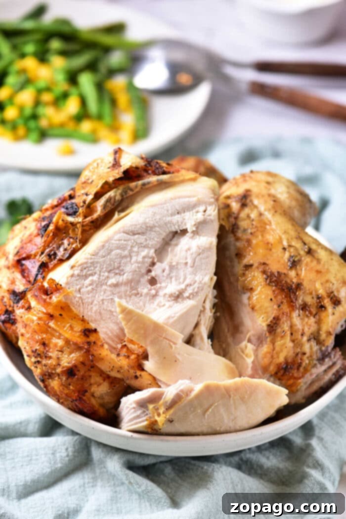 Oven-Baked Beer Can Chicken 5 Crispy golden beer can chicken in oven, sliced and ready to serve, showing juicy interior.