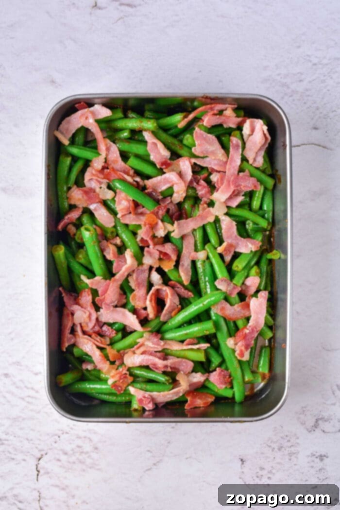 Irresistible Green Beans 9 A close-up of a generous serving of Crack Green Beans, showcasing the rich sauce and bacon, presented as a unique and delicious alternative to a traditional green bean casserole.