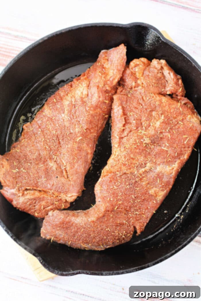 Perfect Oven Roasted Tri Tip 6 A perfectly seared tri-tip steak resting in a cast iron skillet after being removed from the oven.
