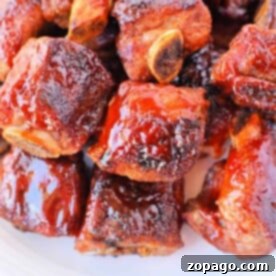 Tender Oven BBQ Riblets 8 A plate of glazed barbecue sauce riblets stacked together, reminiscent of tender baked riblets in the oven.