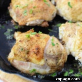Four pieces of seasoned chicken are frying in a black cast iron skillet, garnished with chopped herbs. Wondering how long to bake these savory chicken thighs at 425 for a perfect finish?